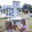 Children playing with a Bird feeder in a park.