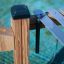 Wooden outdoor xylophone with metal bars and mallet hanging.