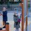 Children playing outdoor musical instruments on playground with Tube Bells.