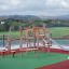 Etna wooden playground structure with climbing ropes and slide.