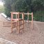 Caucasus wooden playhouse with slide and climbing structure in a playground
