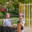 Children playing with outdoor musical drums in a playground.