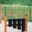 Playground percussion instrument Drums with black cylinders and wooden frame.