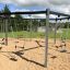 Six Arm Swing Silver playground equipment with six swings on a sandy surface.