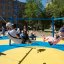Six Arm Swing Silver playground equipment with children playing on swings in a sunny park.