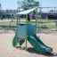 Mars playhouse with slide in a sandy playground.