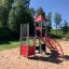 Ladybug playhouse with slide, steel structure in a playground setting