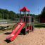 Ladybug playhouse with slide and steel structure in a playground