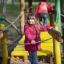 Girl in red jacket on Aliceâ€™s house playground bridge.