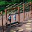 Children playing on Trim Trail Nature II wooden outdoor playground equipment in park