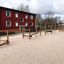 Trim Trail Nature II playground equipment in sandy area near residential building.