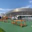 Trim Trail Nature II outdoor fitness course next to a modern arena