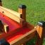 Sand & Water Play - wooden and red plastic play structure in a grassy field
