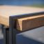 Close-up of Thor table with metal frame and wooden top.