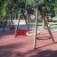 Swings on Rubber Tiles 35 playground surface in a park.