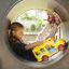 Child playing with Locomotive with cars train playhouse toy in a tube slide.