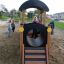 Children playing on Locomotive with cars train playhouse in a playground.