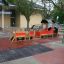 Locomotive with cars train playhouse in playground area.