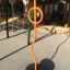 Caterpillar climbing net in a playground with orange climbing structure.
