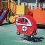 Red Copter rocking playground equipment with playset and slide in background.