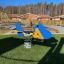 Playground spring rider shaped like a blue and yellow Jet rocking aircraft.