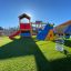 Jet rocking spring rider in a playground with climbing structure and slide in the background.