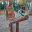 Wooden Nature Seesaw in a playground with slide and climbing structure.