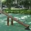 Nature Seesaw in a playground with wooden design and metal handles.
