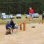 Children playing on Nature Seesaw in a sandy playground.