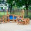 Wooden playground equipment for Sand & Water Play III with benches and tables.