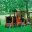Children playing on a wooden Locomotive train playhouse in a green outdoor playground