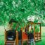 Children playing on a wooden Locomotive train playhouse in a grassy playground