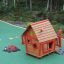 Anna's Playhouse, wooden playhouse with red accents in a colorful playground