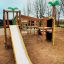 Jungle castle with slide on playground with trees in background.