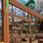 Wooden jungle castle with slide and climbing ropes.
