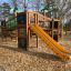 Playground Jungle castle with slide made of wood and decorated with animal motifs.