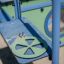 Playground equipment Pluto close-up with green steering wheel and blue climbing structure.