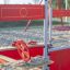 Jupiter playground equipment with a red steering wheel in a sandy play area