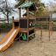 Jungle House playhouse with slide in a playground setting