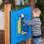 A boy playing with a Bingo Board outdoor game.
