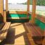 Wooden Bus playhouse with seating benches.