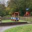 Playground equipment resembling a bus in a park.