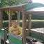 Wooden bus-shaped playground structure with a child inside.