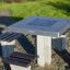 Outdoor chess table with benches on a gravel path.