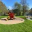 Helicopter playground structure with slide and climbing net on sandy area in park