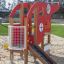 Red Helicopter themed playground equipment on a sandy playground.