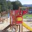 Colourful playground structure called Helicopter with slide and climbing elements in a park.