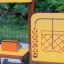 Stall playground equipment with yellow panel and interactive play elements
