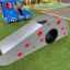 Children's playground slide Dottie I single slide with red polka dots on green turf.