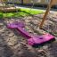 Double Seat swing on a playground with sandy ground.